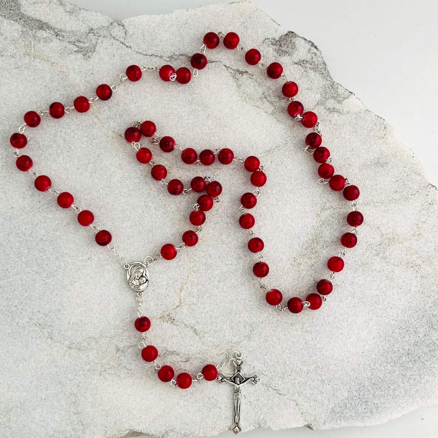 These beautiful Red Rosary are handcrafted in Jerusalem and contain a small capsule of Holy Earth from the Holy Land. Each bead is a reminder of prayer, devotion, and the sacred ground where Christ walked. Ideal for daily prayer or as a meaningful gift, this rosary connects the faithful to the spiritual heart of Christianity.