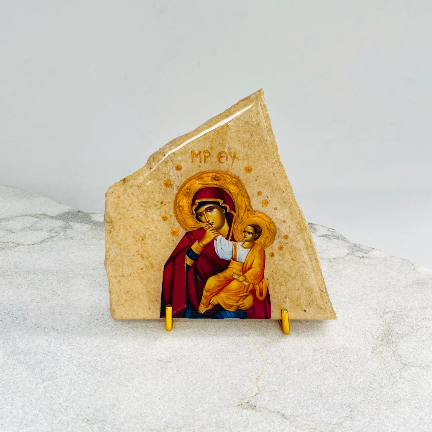 Panayia Mary-Mother of Jesus icon is carefully handcrafted on Travertine covered with a clear hypoxy resin.  Comes with a gold stand.