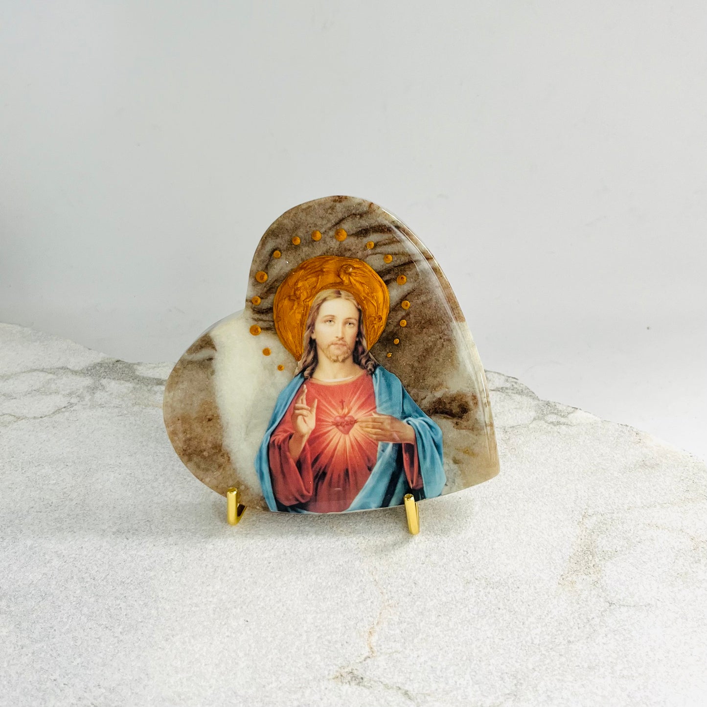 Sacred Heart Jesus is carefully handcrafted on a Love Heart Onyx covered with a clear hypoxy resin.  Comes with a white stand.