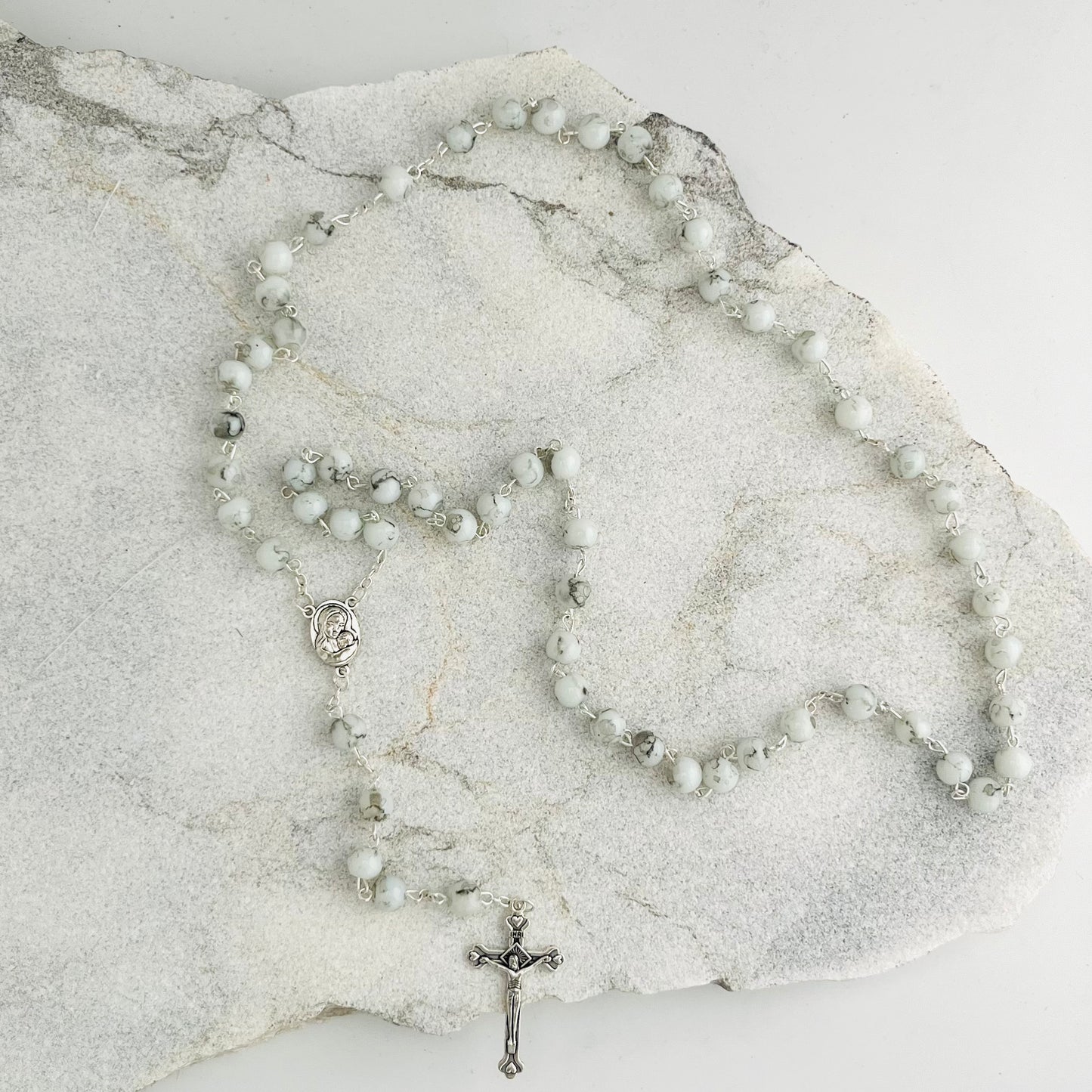 These beautiful White Rosary are handcrafted in Jerusalem and contain a small capsule of Holy Earth from the Holy Land. Each bead is a reminder of prayer, devotion, and the sacred ground where Christ walked. Ideal for daily prayer or as a meaningful gift, this rosary connects the faithful to the spiritual heart of Christianity.