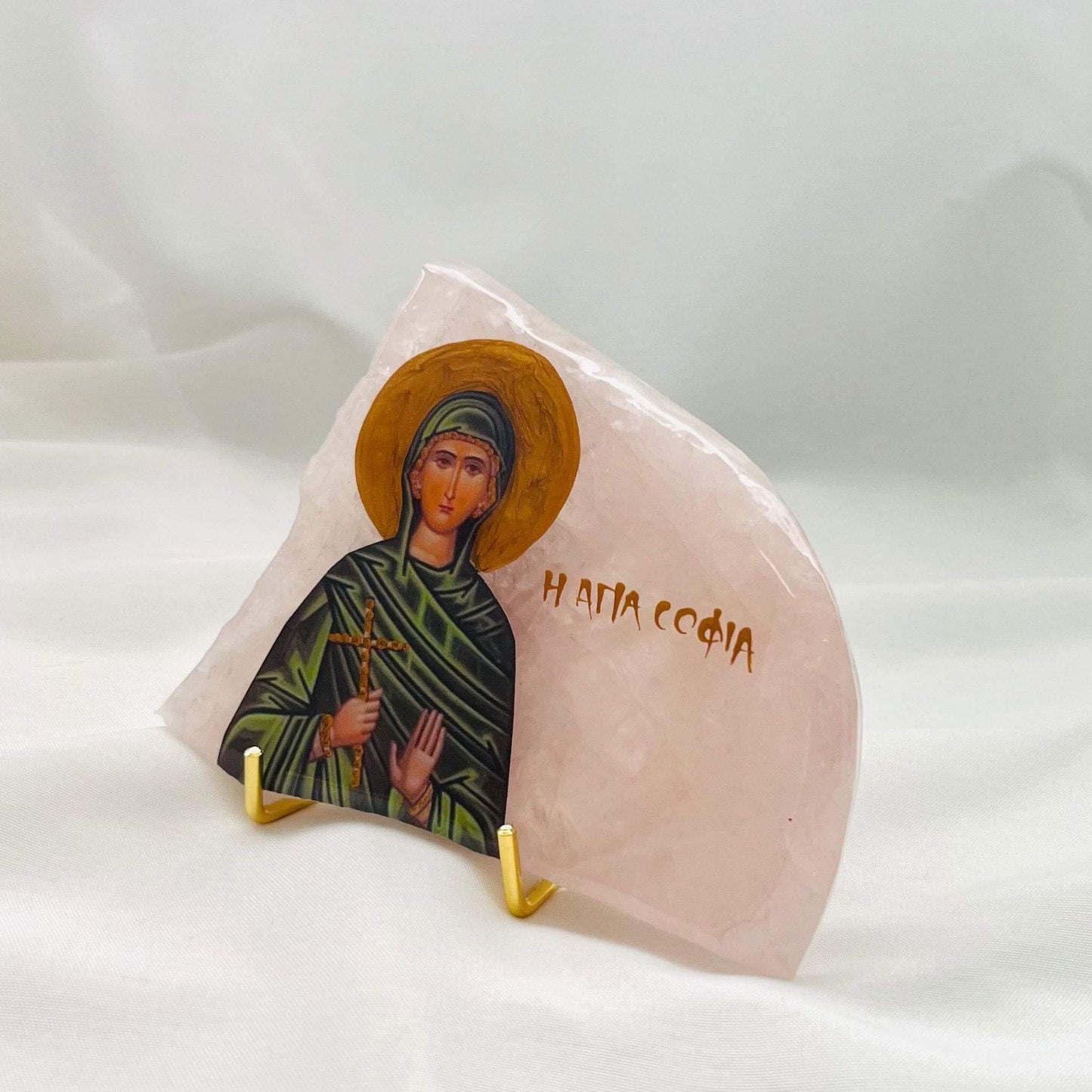 Agia Sofia / Saint Sofia Icon is carefully handcrafted on Rose Quartz, covered with a clear hypoxy resin.  Comes with a gold stand.